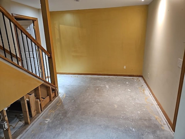 unfurnished room featuring stairs and baseboards