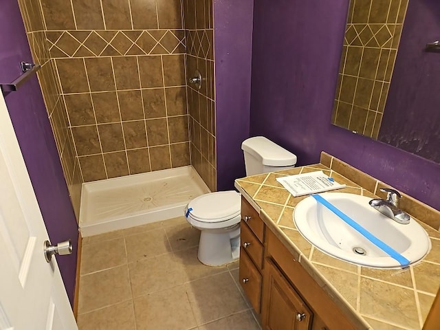 bathroom with tile patterned floors, toilet, a stall shower, and vanity