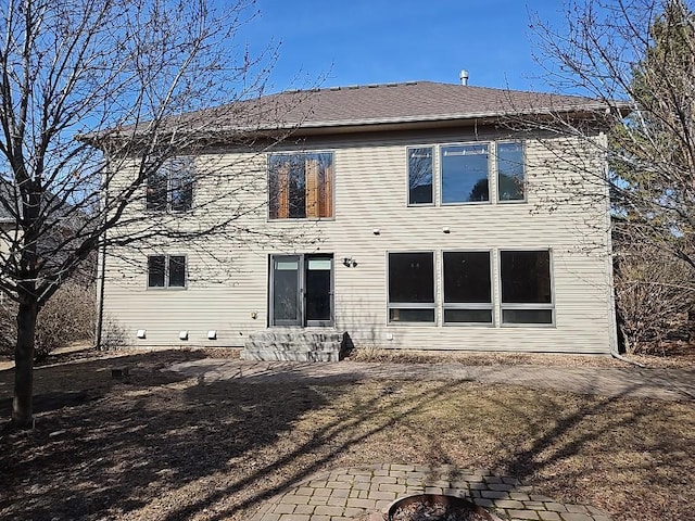 rear view of house with a shingled roof