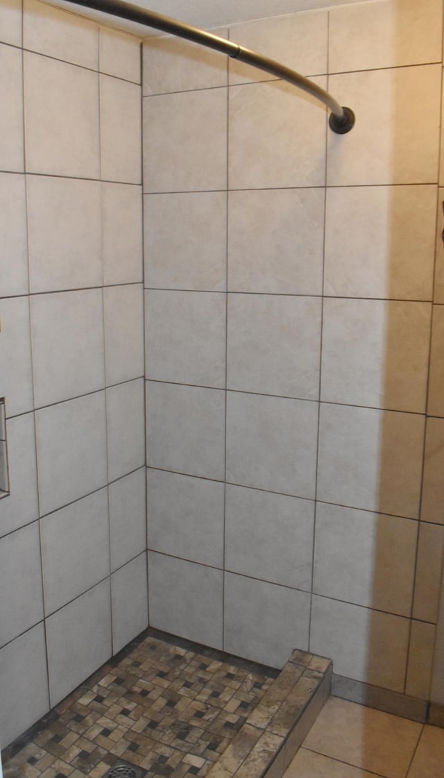 full bath featuring tiled shower