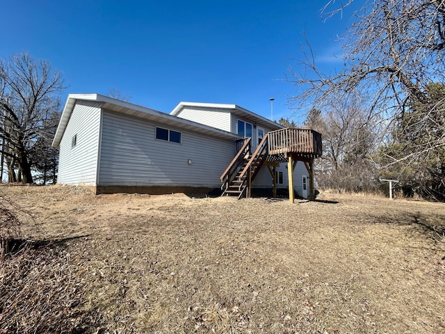 back of property featuring stairway and a deck