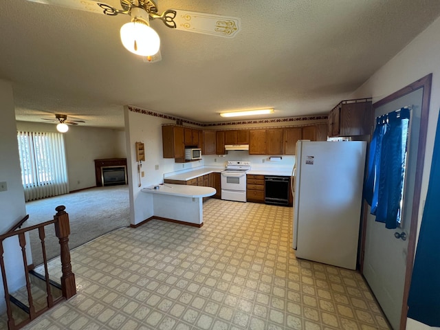 kitchen with under cabinet range hood, open floor plan, white appliances, a fireplace, and light countertops