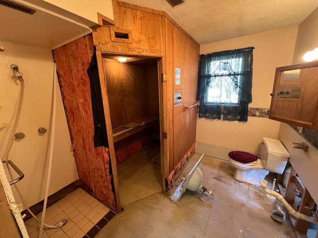 bathroom with visible vents, toilet, a textured ceiling, and baseboards