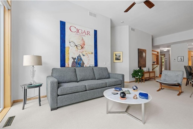 carpeted living room with visible vents, baseboards, and ceiling fan