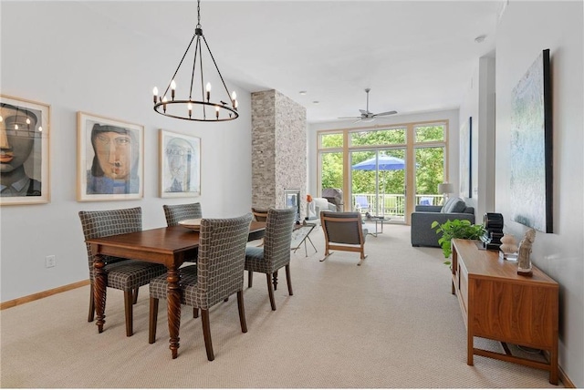 dining area featuring light carpet, a ceiling fan, and baseboards