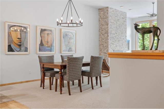 carpeted dining area featuring a ceiling fan and baseboards