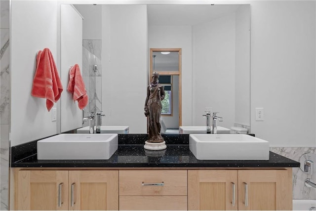 full bath featuring double vanity and a sink