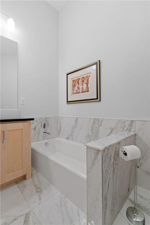 bathroom featuring vanity, wainscoting, a garden tub, tile walls, and marble finish floor