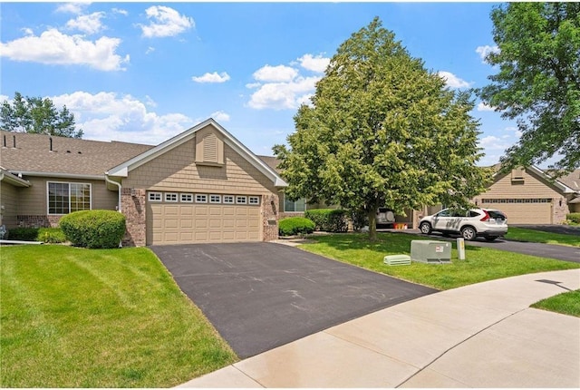 view of front facade with aphalt driveway, an attached garage, brick siding, and a front lawn