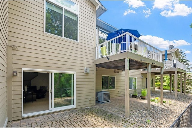 rear view of property featuring a patio area, cooling unit, and a deck