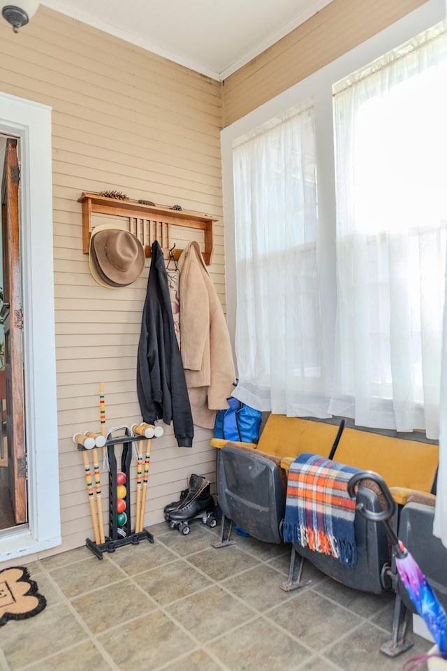 mudroom featuring wooden walls and crown molding