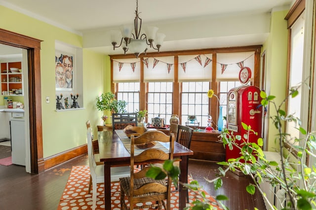 dining room with an inviting chandelier, dark wood-style floors, baseboards, and a wealth of natural light