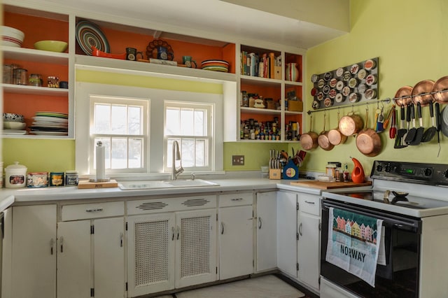 kitchen featuring open shelves, light countertops, electric stove, white cabinetry, and a sink