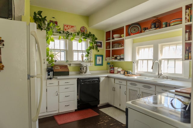 kitchen featuring a sink, open shelves, black dishwasher, freestanding refrigerator, and range