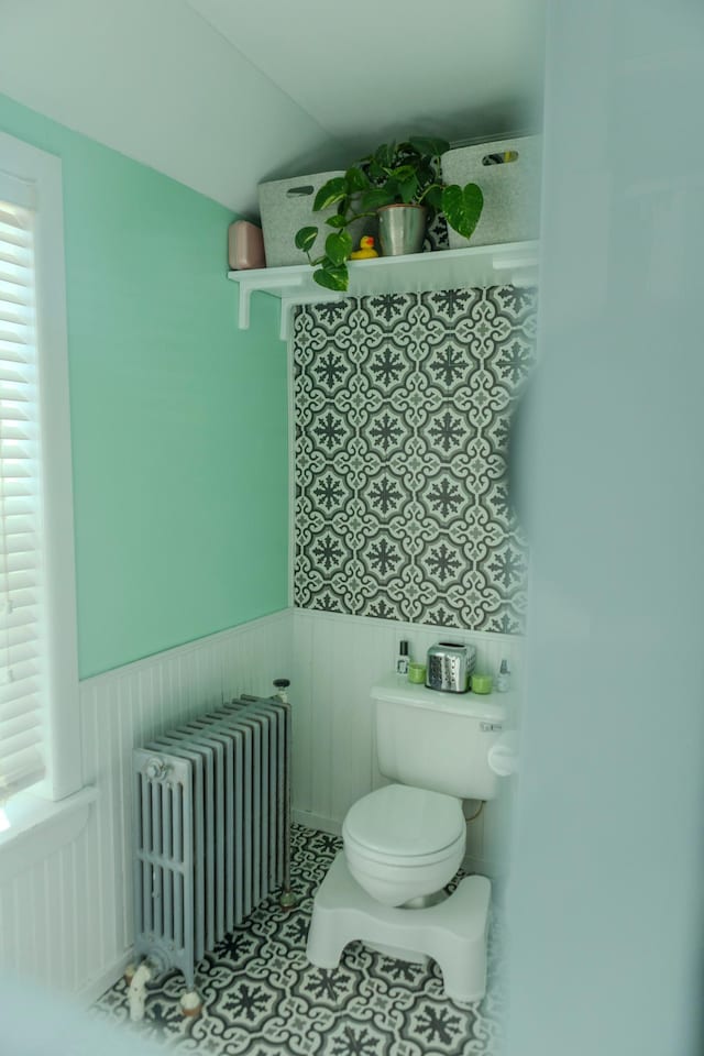 bathroom featuring tile patterned floors, radiator, wainscoting, and toilet