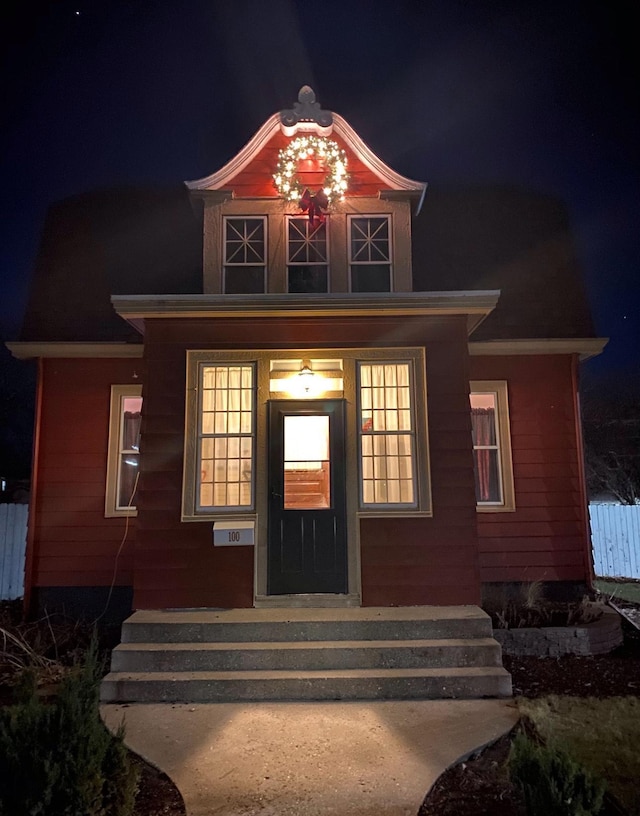 exterior entry at night with covered porch and fence