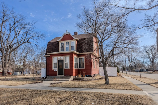 dutch colonial with a chimney, a gambrel roof, and a shingled roof