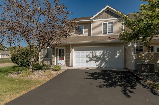 view of front of house with central AC unit, board and batten siding, and driveway