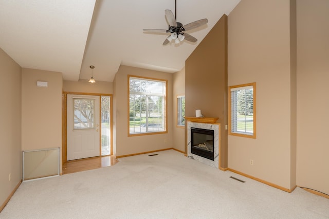 unfurnished living room featuring carpet flooring, baseboards, visible vents, and a premium fireplace