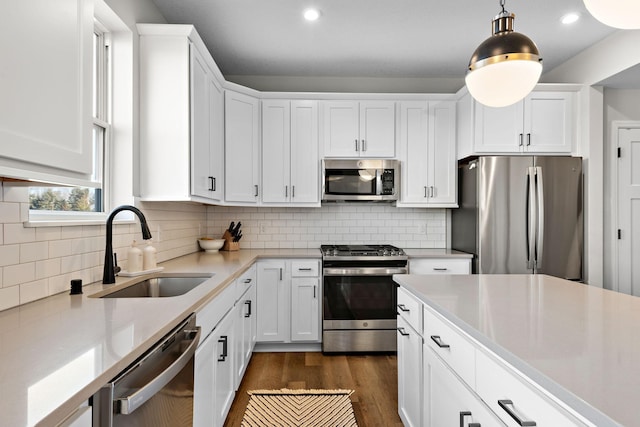 kitchen featuring a sink, white cabinetry, stainless steel appliances, light countertops, and dark wood-style flooring