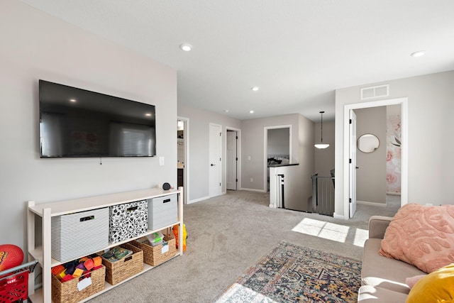 carpeted living area featuring recessed lighting, baseboards, and visible vents