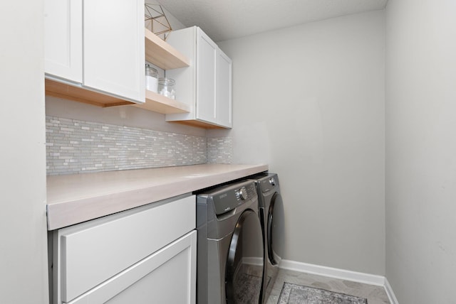 laundry area with baseboards, cabinet space, and washing machine and clothes dryer