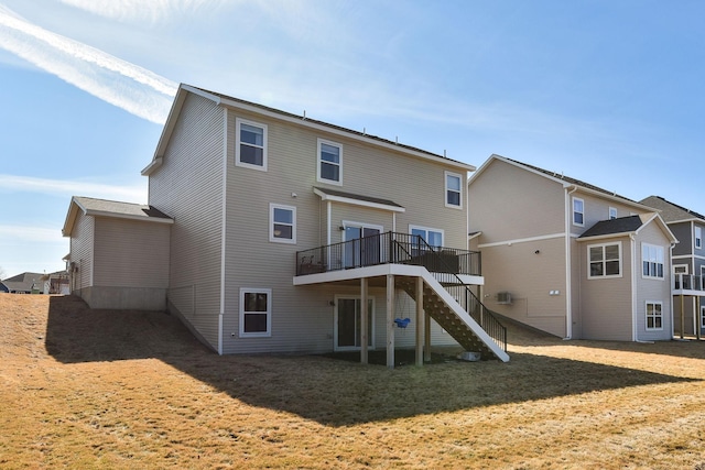 rear view of property with a yard, a wooden deck, and stairs