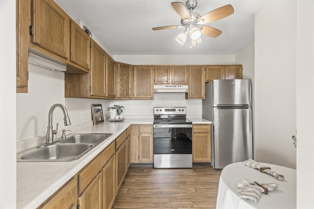 6615 Lake Shore Dr S Unit 515, Richfield, MN 55423 - kitchen with stainless steel appliances, under cabinet range hood, a sink, light countertops, and wood finished floors
