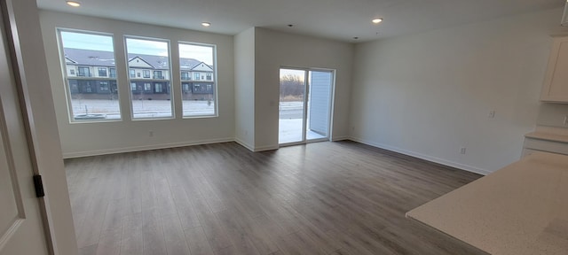 unfurnished dining area with recessed lighting, baseboards, and wood finished floors