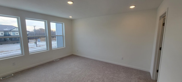 spare room featuring visible vents, baseboards, and carpet