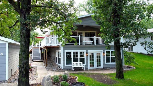 rear view of property featuring a patio area, stairway, a lawn, and french doors