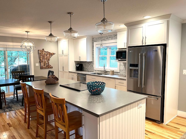 114 Bay View Rd, Otter Tail Twp, MN 56571 - kitchen featuring stainless steel appliances, a sink, light wood finished floors, decorative backsplash, and a kitchen island