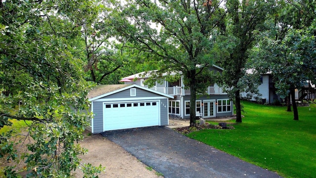 114 Bay View Rd, Otter Tail Twp, MN 56571 - view of property hidden behind natural elements featuring driveway, a front yard, french doors, a balcony, and an attached garage