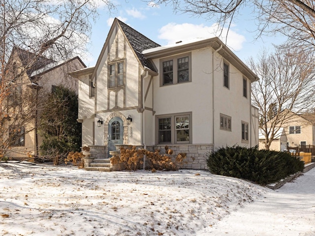 tudor house featuring stone siding and stucco siding