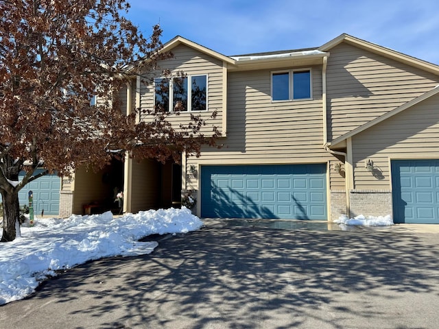 view of front of home with brick siding, driveway, and an attached garage