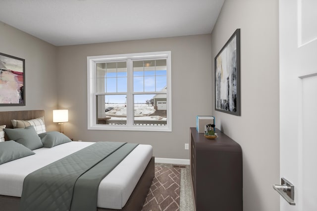 bedroom with baseboards and dark colored carpet