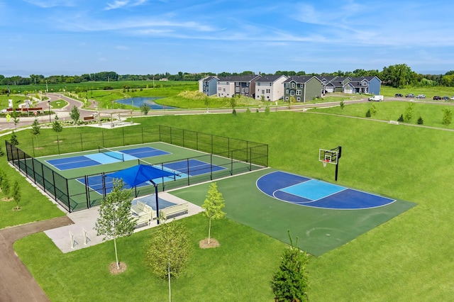 view of sport court with a tennis court, community basketball court, fence, a yard, and a residential view