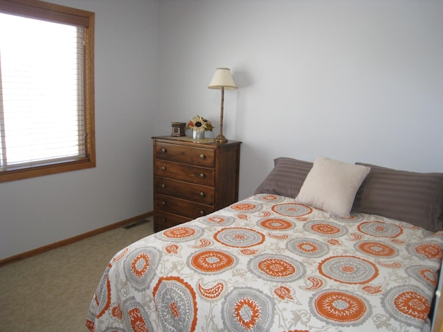 carpeted bedroom featuring visible vents and baseboards