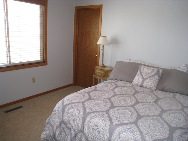 carpeted bedroom with baseboards and visible vents