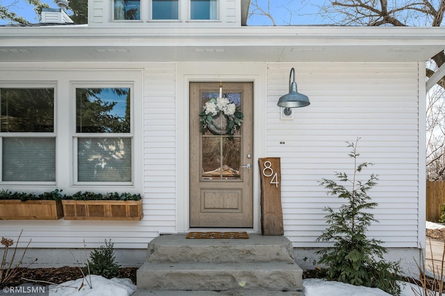 view of exterior entry with a chimney