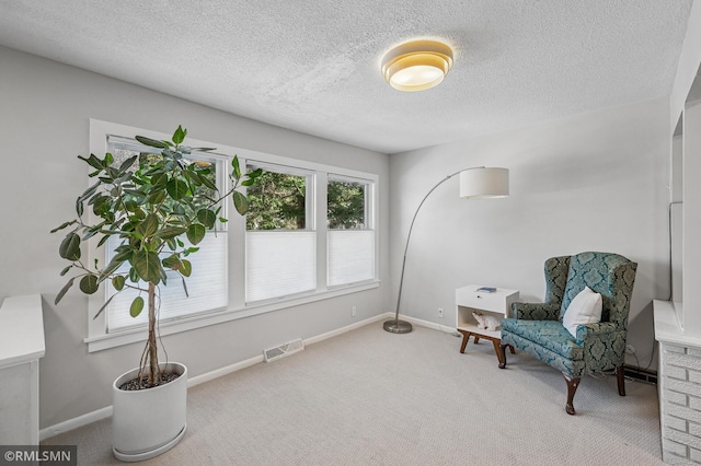 sitting room featuring visible vents, carpet floors, and baseboards