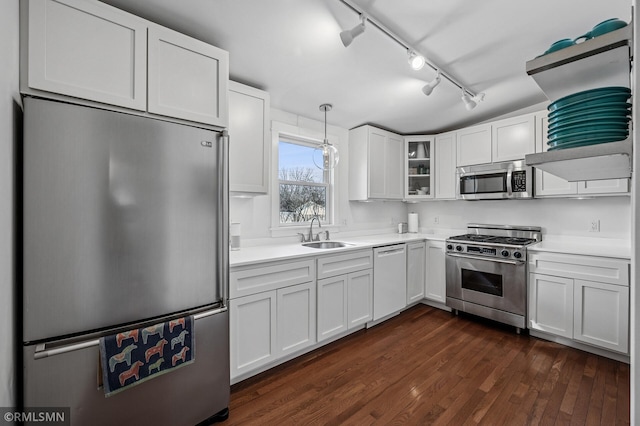 kitchen with white cabinets, stainless steel appliances, light countertops, and a sink