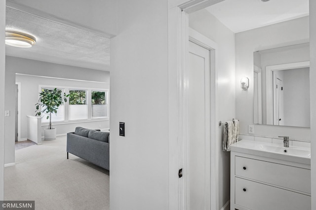 bathroom with vanity, baseboards, and a textured ceiling