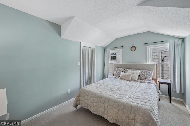 carpeted bedroom with lofted ceiling, baseboards, and a textured ceiling