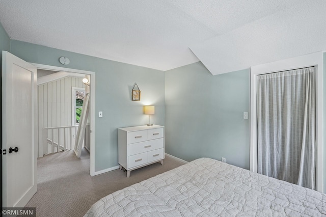 bedroom featuring carpet, baseboards, and a textured ceiling