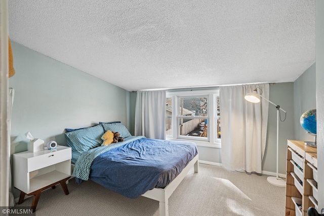 carpeted bedroom with a textured ceiling and baseboards