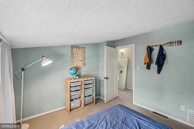 carpeted bedroom featuring visible vents, baseboards, and a textured ceiling