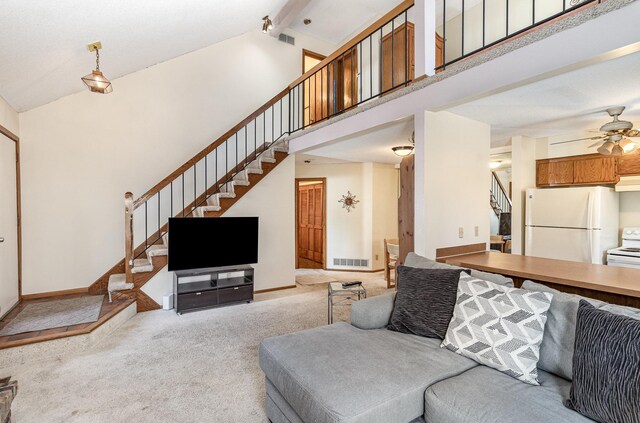 living room with visible vents, high vaulted ceiling, carpet flooring, baseboards, and stairs