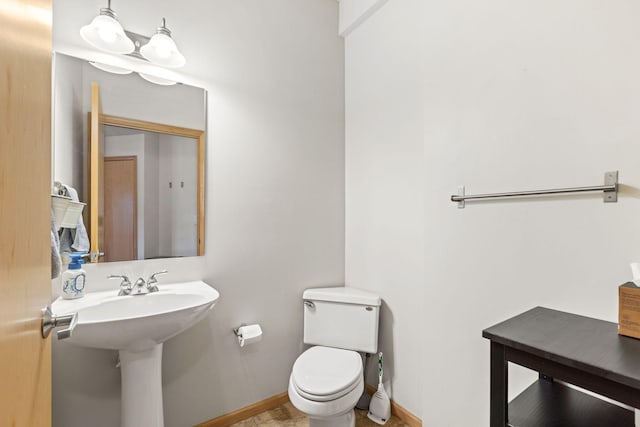 bathroom with toilet and baseboards