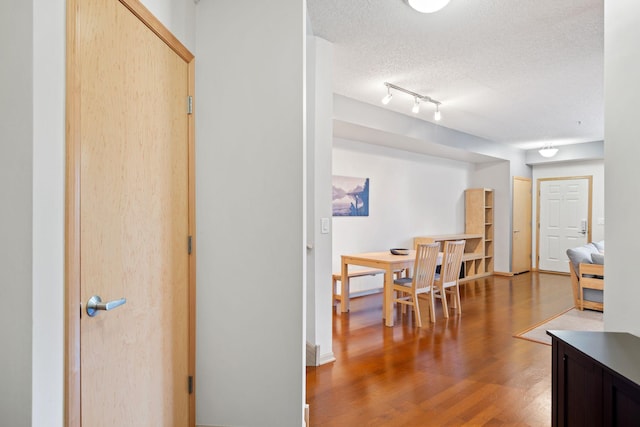 hall featuring wood finished floors and a textured ceiling